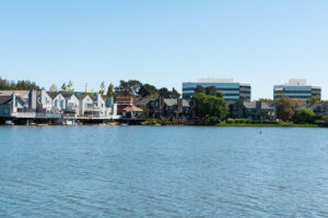 A scenic view of Seal Slough in San Mateo, California, showcasing a serene waterfront with homes and modern office buildings under a bright, sunny sky. The image captures the affluent and educational ambiance of San Mateo, indicative of the high-quality private schools in the area. The picturesque setting reflects the conducive learning environment provided by San Mateo's private schools, nestled in this idyllic Californian city.